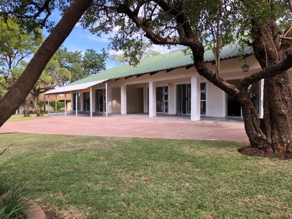 ein Gebäude mit einem Baum davor in der Unterkunft Tshikwalo Guest House in Klipdrift