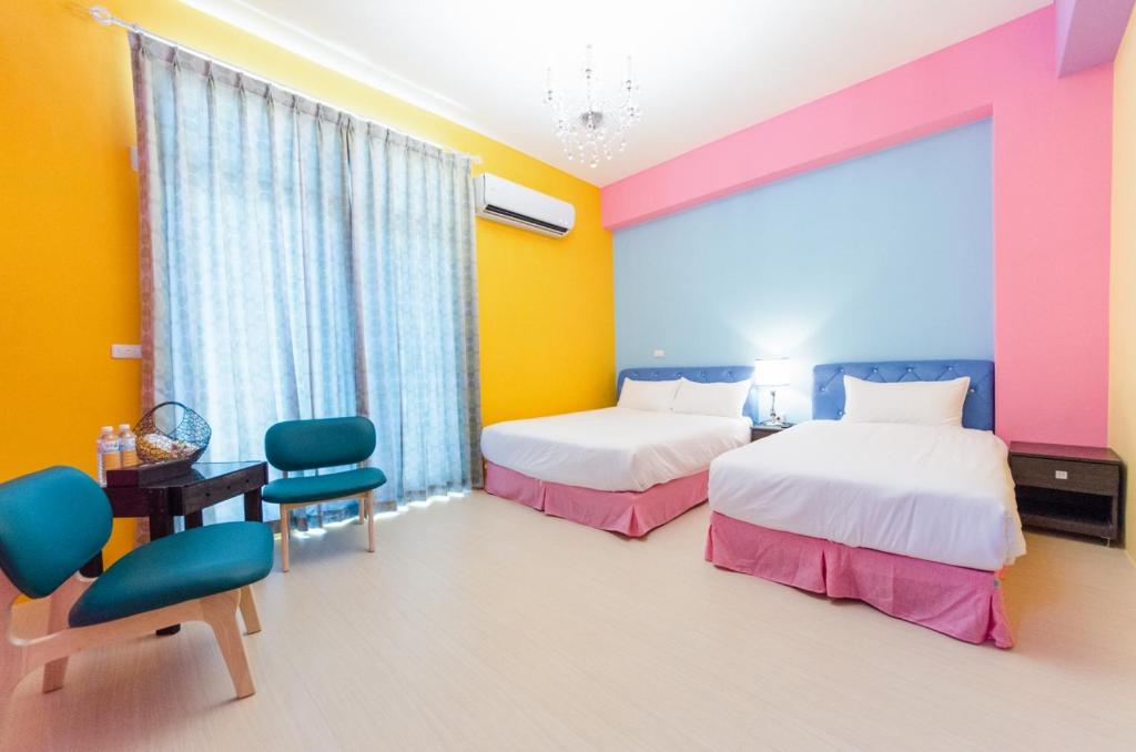 a room with two beds and a table and chairs at Love Love Taitung in Taitung City