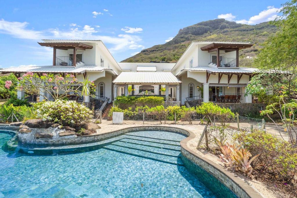 an exterior view of a house with a swimming pool at Domaine Harmonia - Group Retreat by Sealodge Mauritius in Rivière Noire