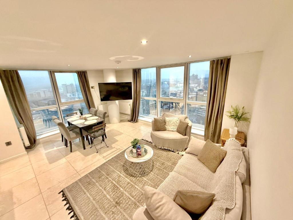 un salon avec un canapé et une table dans l'établissement 22nd Floor Luxury City Centre Apartment, à Belfast