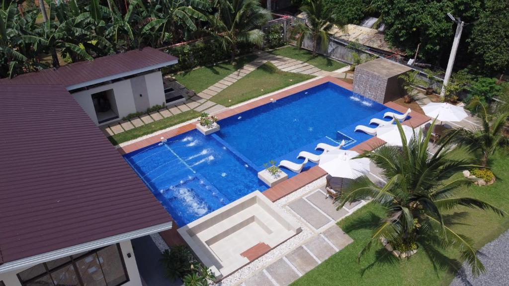 einen Blick über einen Pool mit Stühlen und ein Haus in der Unterkunft Agricio Farm and Resort 