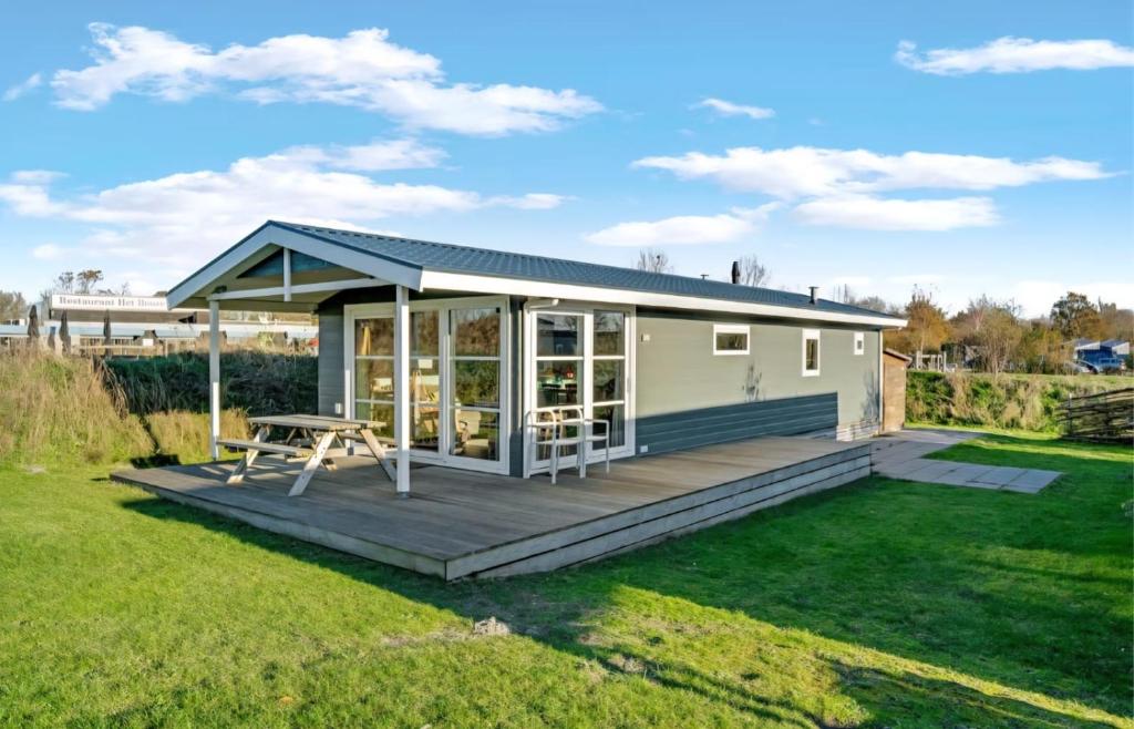 ein winziges Haus mit einer Terrasse im Hof in der Unterkunft Strandhuis `Meerzicht` in Lauwersoog