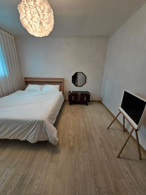 ein Schlafzimmer mit einem Bett und einem Flachbildfernseher in der Unterkunft 장원숲채 in Hagwanggyo-dong