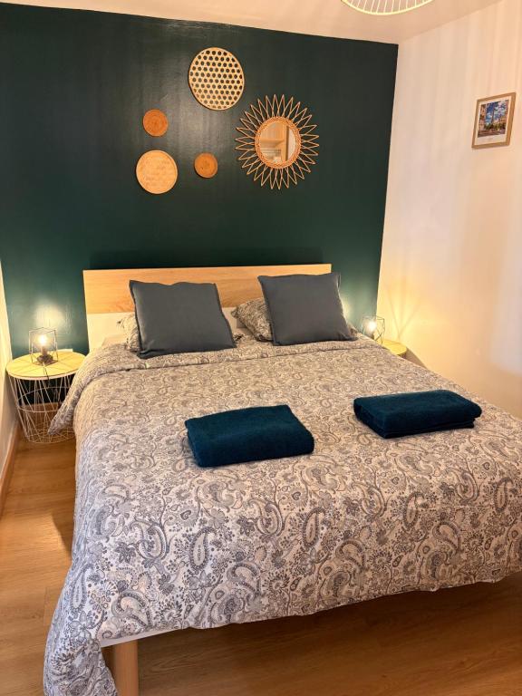 a bedroom with a bed with two pillows on it at L'atelier du Charme Dole Centre in Dole