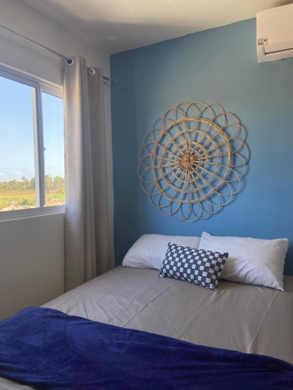 a bedroom with a blue wall with a clock on the wall at Casa aconchegante em Parnaíba in Parnaíba