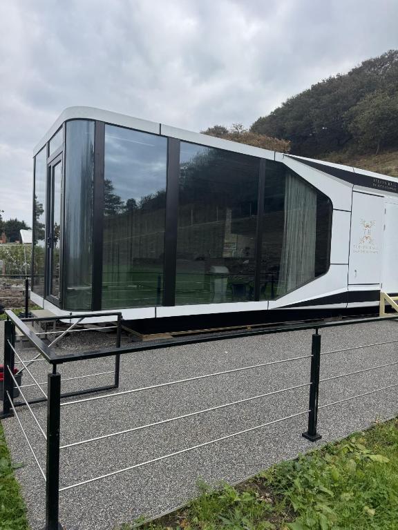 a glass house on the side of a road at Galactic getaways JUPITER in Prestatyn
