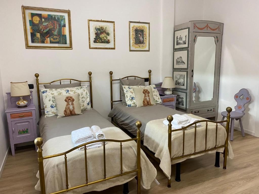 ein Schlafzimmer mit zwei Betten und einem Spiegel in der Unterkunft CASCINA LAI - Oasi Naturalistica - Camere private in Santena