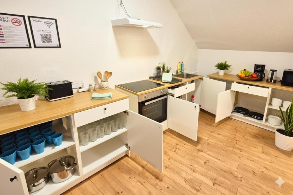 eine offene Küche mit weißen Schränken und blauen Geräten in der Unterkunft L21-Apartment Flensburg, 5 Zimmer, 14 Betten, Standardisierte Ausstattung, ideal für Reisende, Pendler, Familien in Flensburg