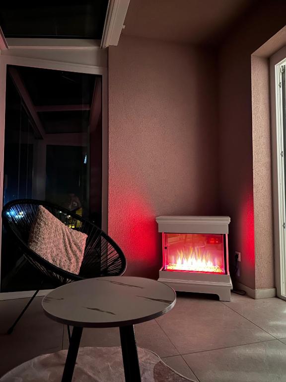 a room with a fireplace and a table and a chair at Apartment Una in Kupres