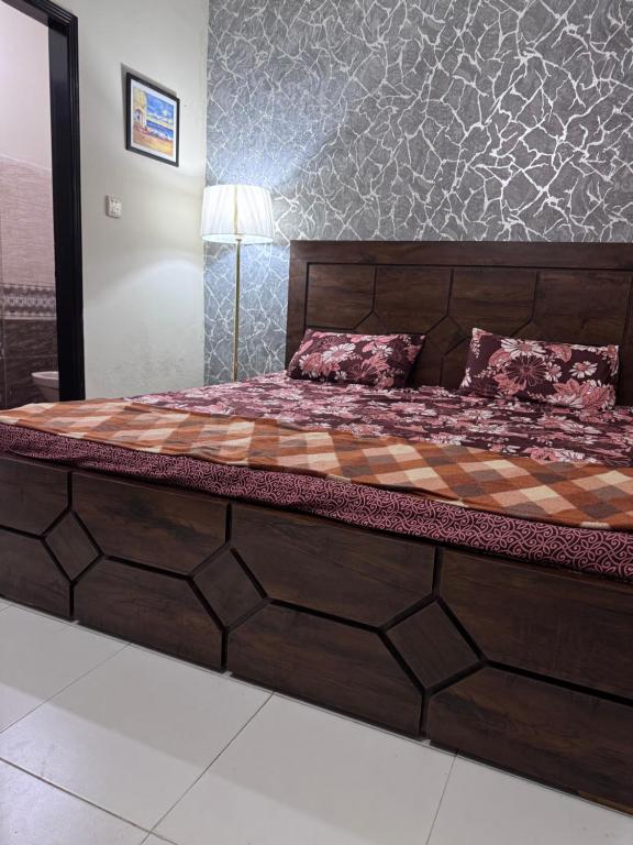 ein großes Holzbett in einem Zimmer mit in der Unterkunft The Ultimate Beachfront Oasis in Karatschi