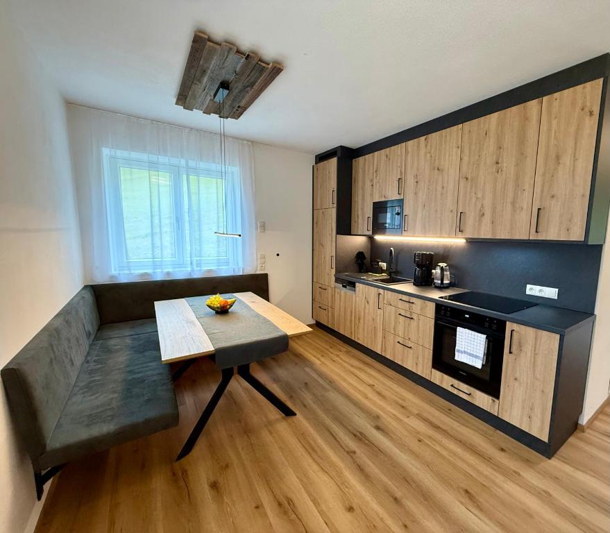 Una cocina con un sofá y una mesa en una habitación. en Haus Schernthaner, en Saalbach Hinterglemm