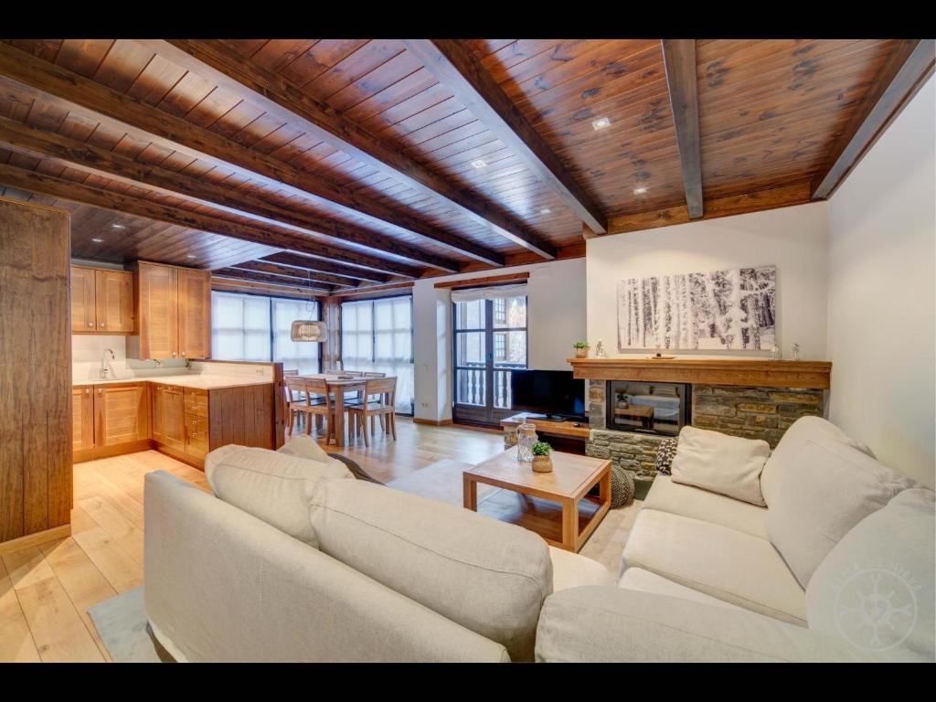 a living room with two couches and a kitchen at Carreretes de Alma de Nieve in Barruera