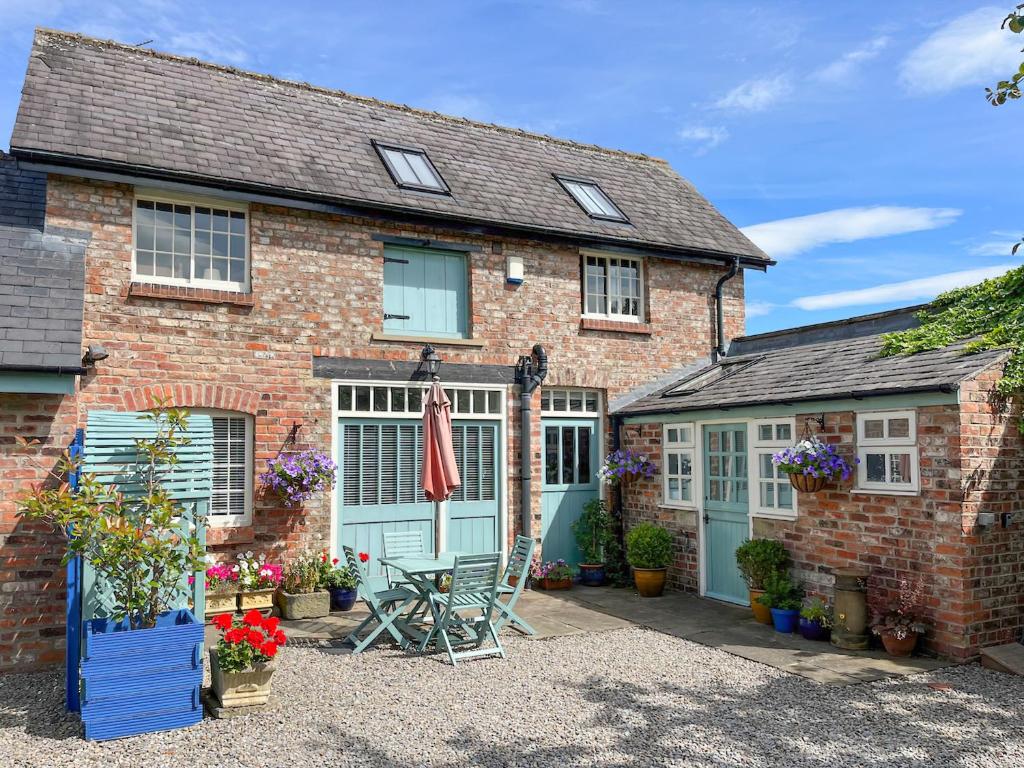 ein rotes Backsteinhaus mit einer blauen Tür in der Unterkunft The Old Coach House in York