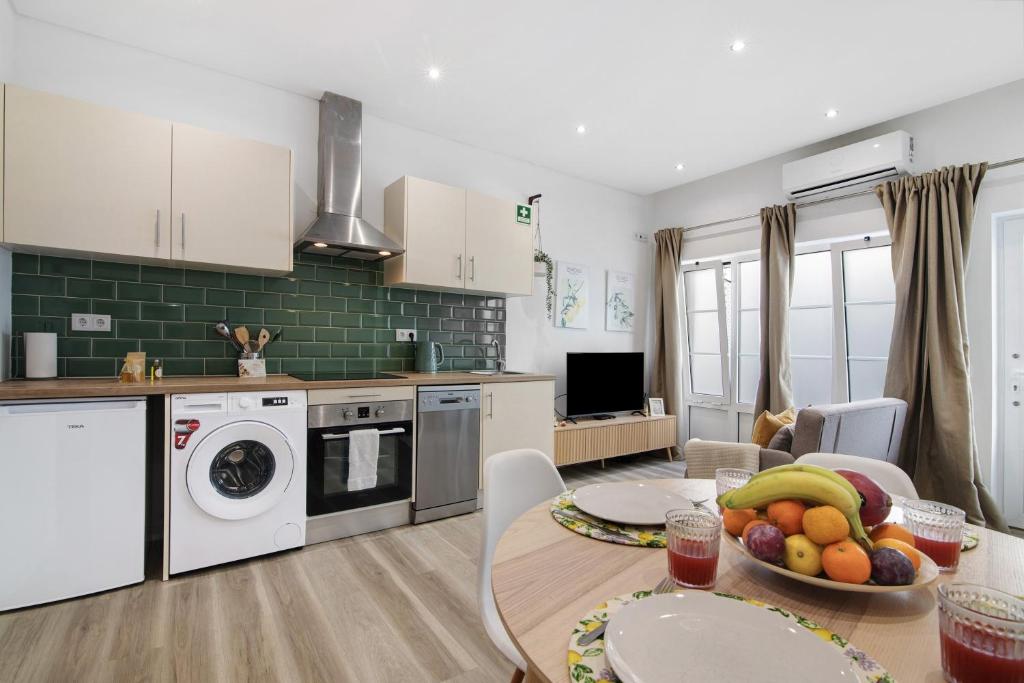 a kitchen with a table with a bowl of fruit on it at Central Studio – Flor De Sol in Tavira