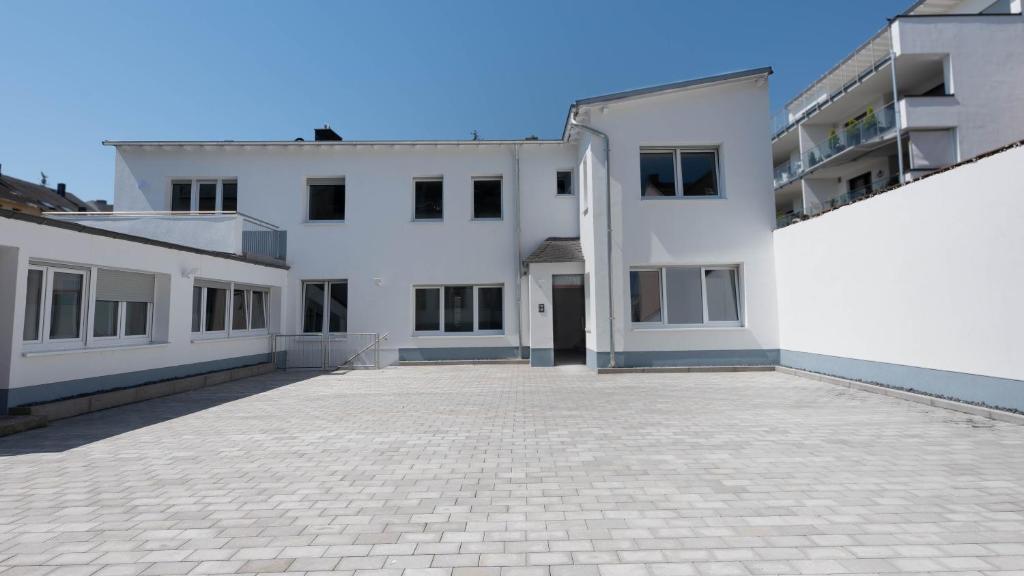 a large white building with a brick courtyard at Gemütliches Zimmer im Herzen der Stadt in Neuwied