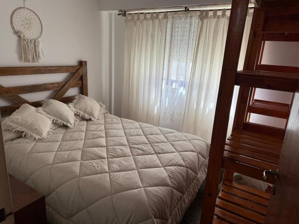 a bedroom with a bed with pillows and a window at Departamento céntrico en San Bernardo in San Bernardo