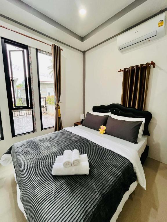 a bedroom with a large bed with two towels on it at Cozy Hideaway 2 BR Private Room Shared House in Ban Tha Khun