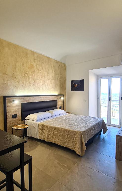a bedroom with a large bed and a large window at Borgo Marchetti in Camerano
