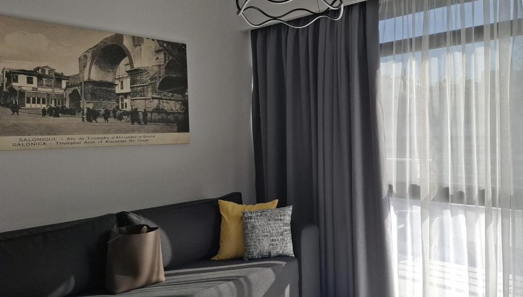 ein Wohnzimmer mit einer Couch und einem Fenster in der Unterkunft Vardaris Apartments Ilion in Thessaloniki