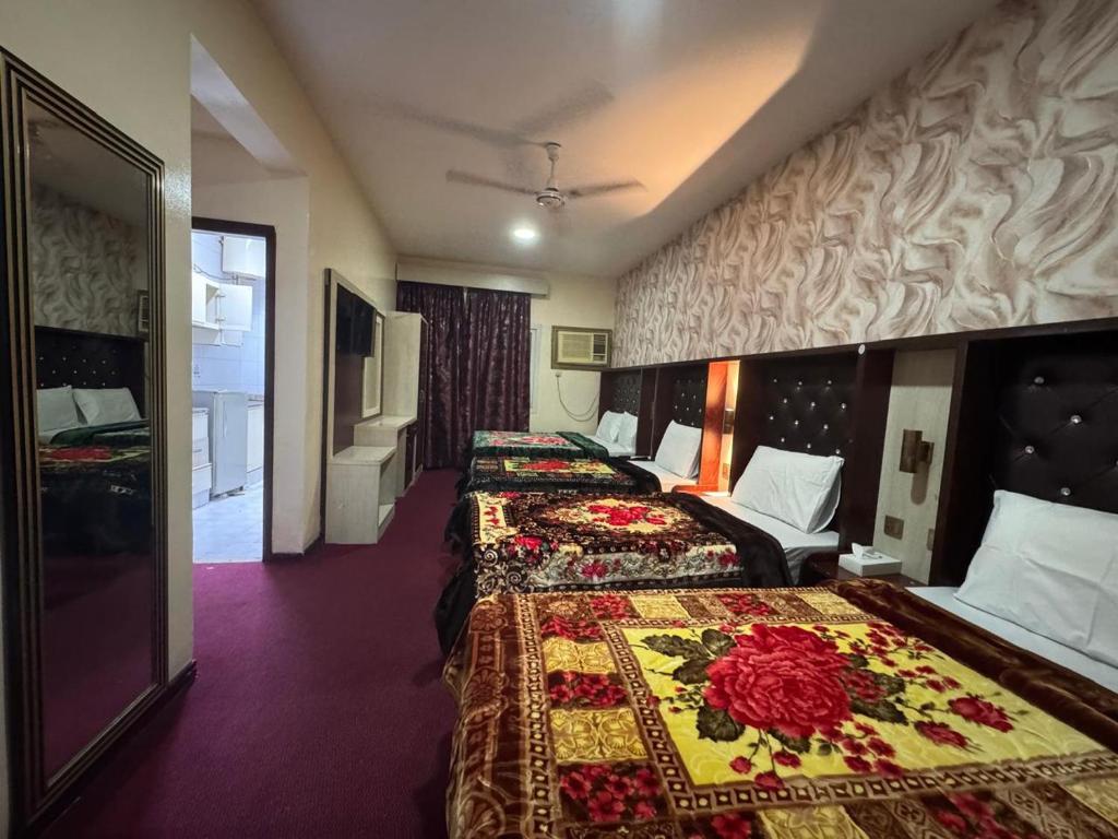 ein Hotelzimmer mit zwei Betten mit Blumen darauf in der Unterkunft Quality Hotel Apartments in Sabkhah