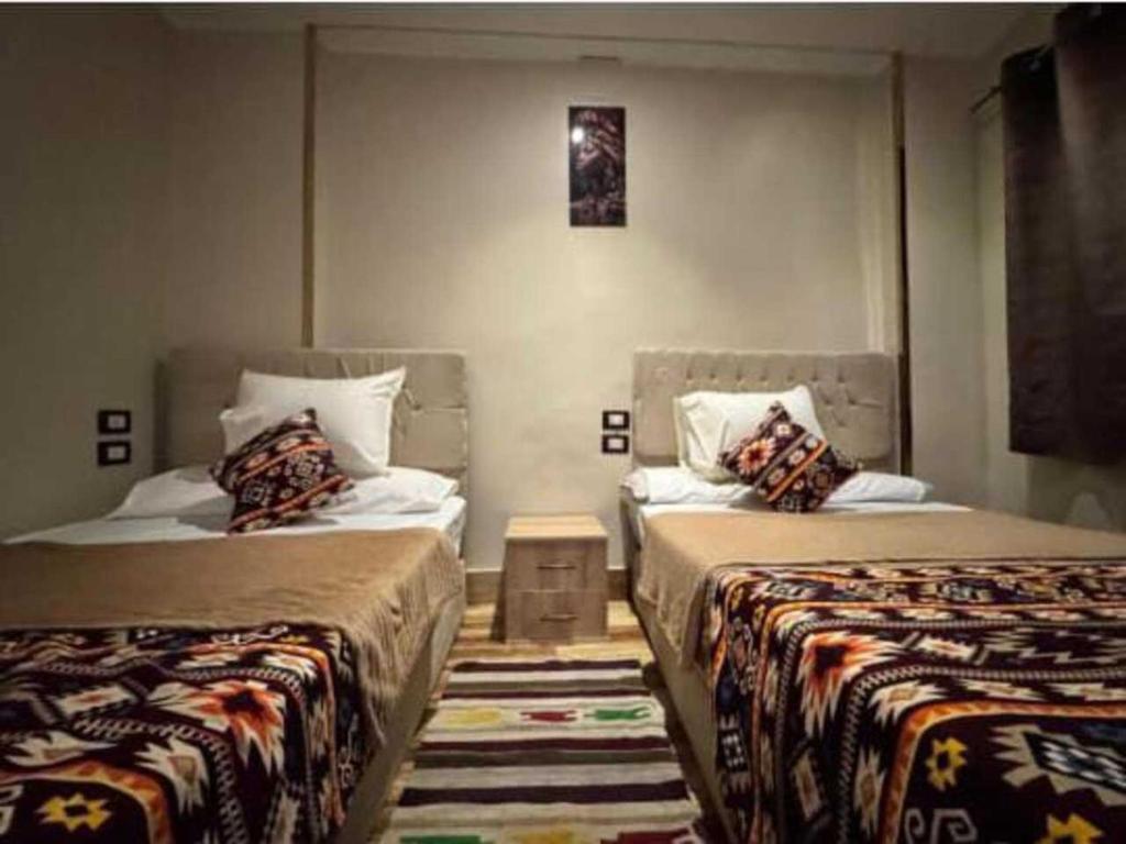 Dos camas en una habitación de hotel con dos camas. en Gannet Alyousef City Center, en Naj‘ al Maḩaţţah