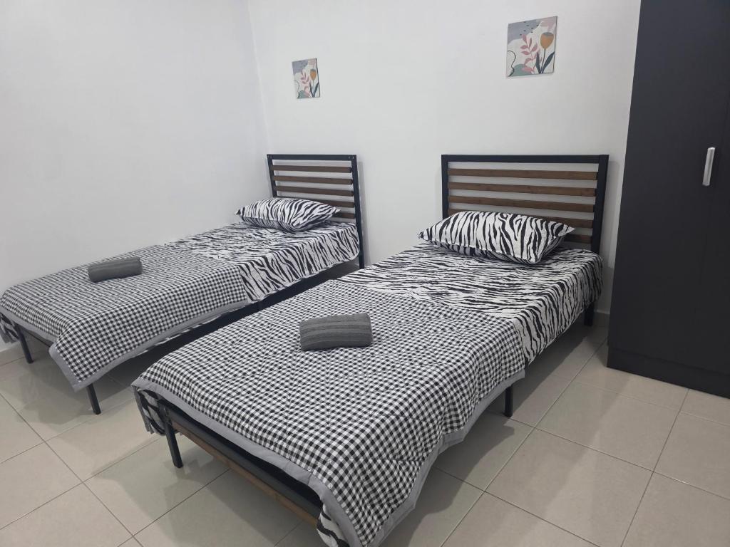 deux lits côte à côte dans une pièce dans l'établissement D'Stay Anak Dara Kijal, à Kijal