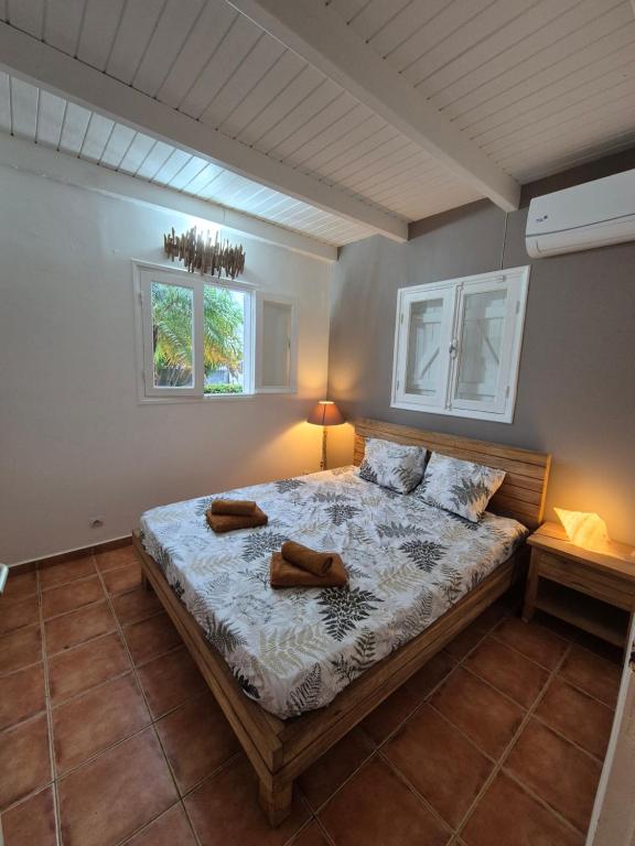 ein Schlafzimmer mit einem Bett mit zwei Schuhen drauf in der Unterkunft Villa malaurelia in Saint-François