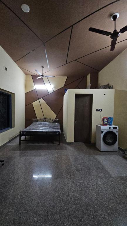 ein leeres Zimmer mit einem Bett und einer Mikrowelle in der Unterkunft Exit 96 Farm Stay in Pāli