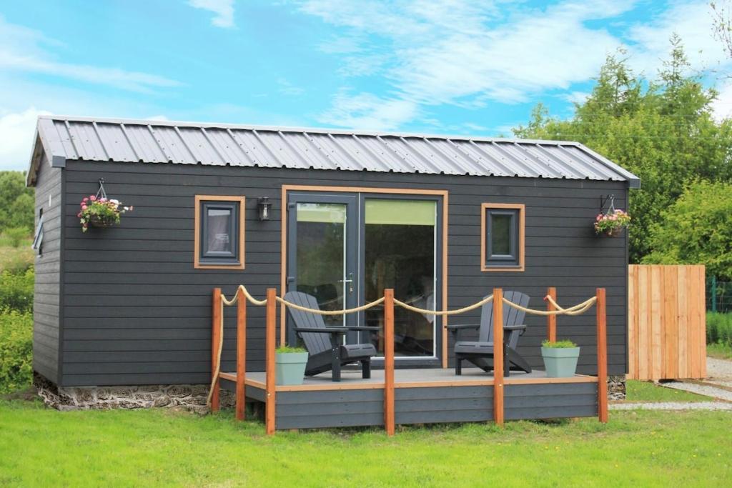a black tiny house with a deck at Quiet Skye Winter hideaway Moluag in Portree