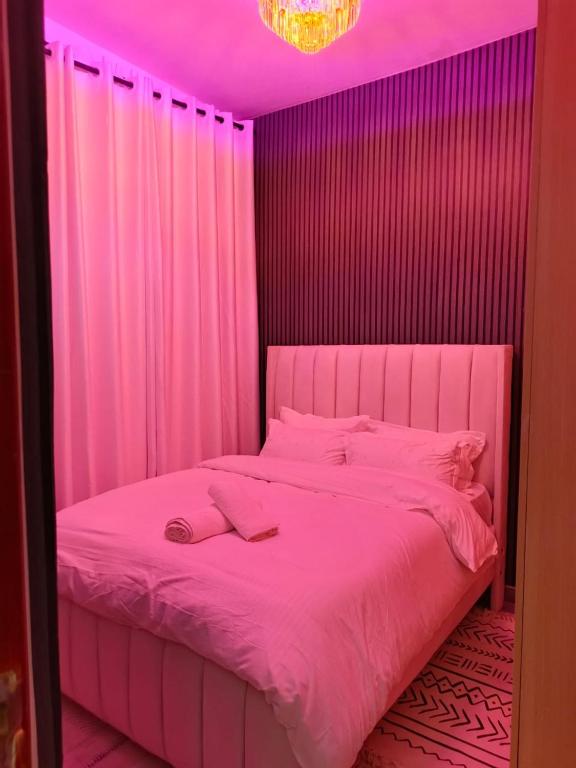 a pink bedroom with a bed with a pink ceiling at Serene luxe homes in Thika