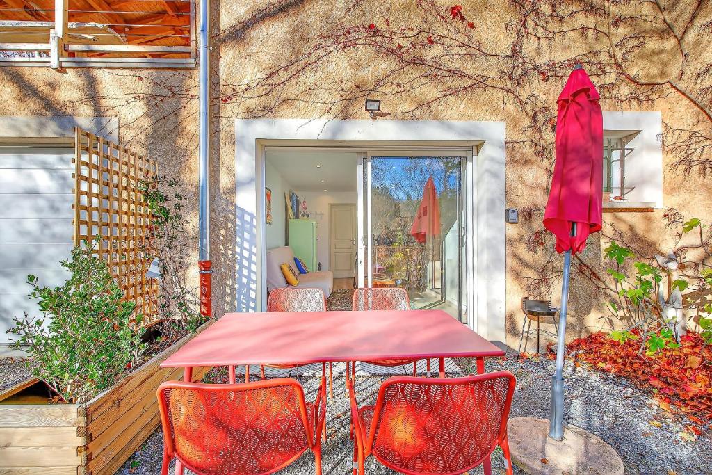 tavolo e sedie rossi di fronte a un edificio di Cap à Gap T2 Bas De Villa a Gap