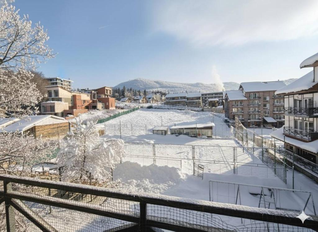 eine mit Schnee bedeckte Eisbahn in einer Stadt in der Unterkunft მგზავრები Mgzavreni IV აპარტამენტი Apartment 205 in Itʼkhvisi