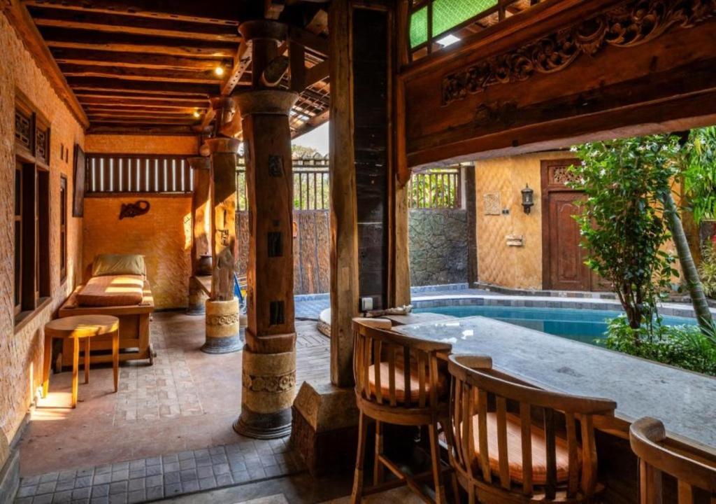 une terrasse avec une piscine, une table et des chaises dans l'établissement Villa Honey, à Montongbuwoh