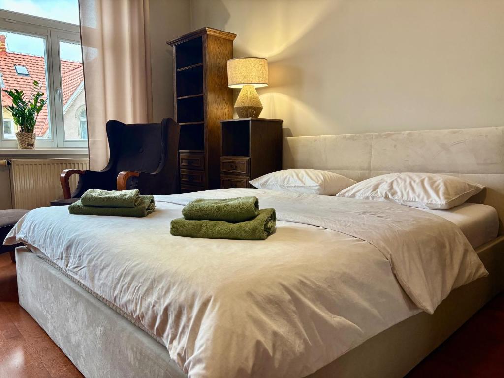 ein Schlafzimmer mit einem Bett mit zwei grünen Kissen darauf in der Unterkunft Kawka i herbatka in Zielona Góra