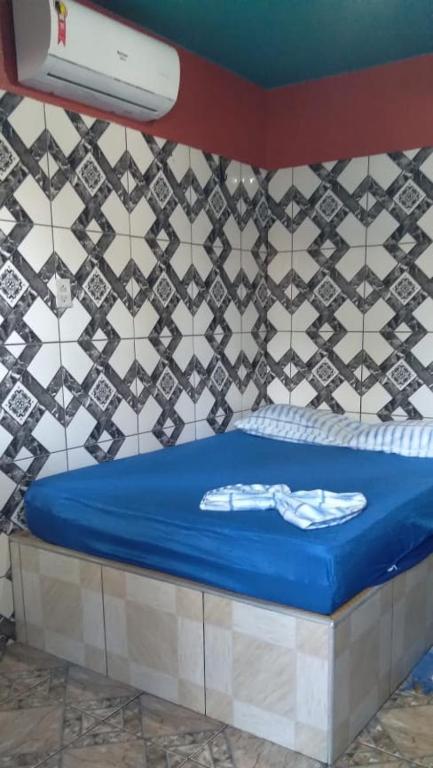 a room with a blue bed with a wall at Point da ilha in Belém