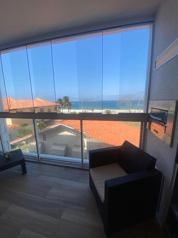 a living room with a large window with a couch at Piratininga - Niterói RJ in Niterói