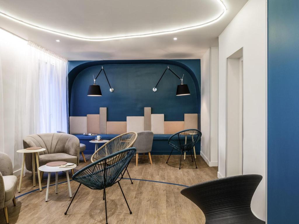 a living room with chairs and a blue wall at ibis Styles Asnieres Centre in Asnières-sur-Seine