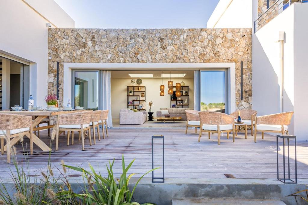 a patio with a table and chairs and a living room at Villa Yaya in Cervione
