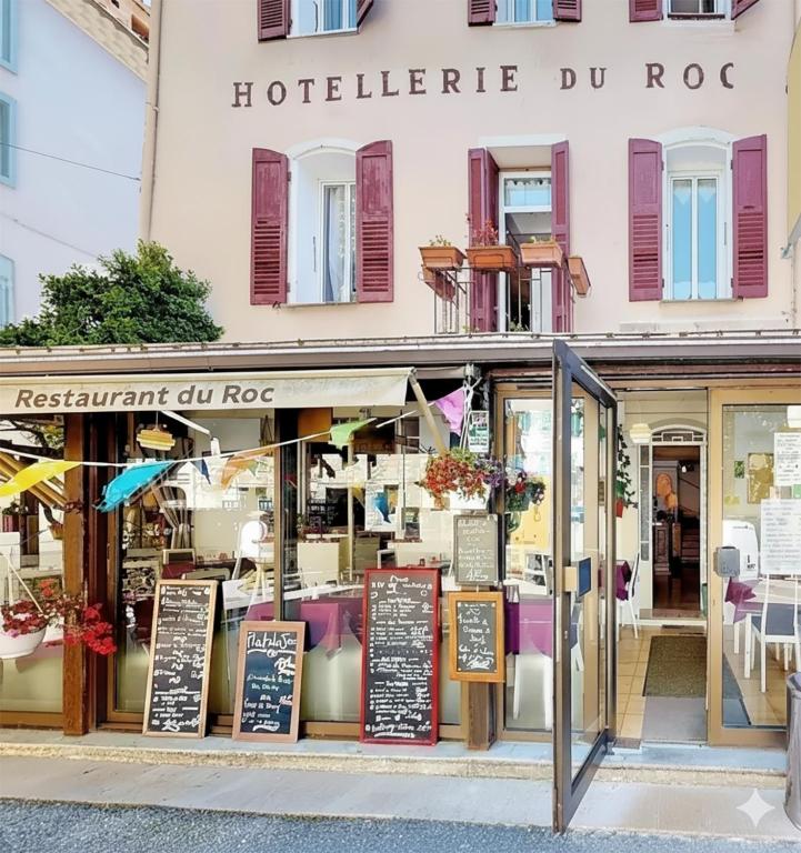 a store with signs in front of a building at Hôtel du Roc in Castellane