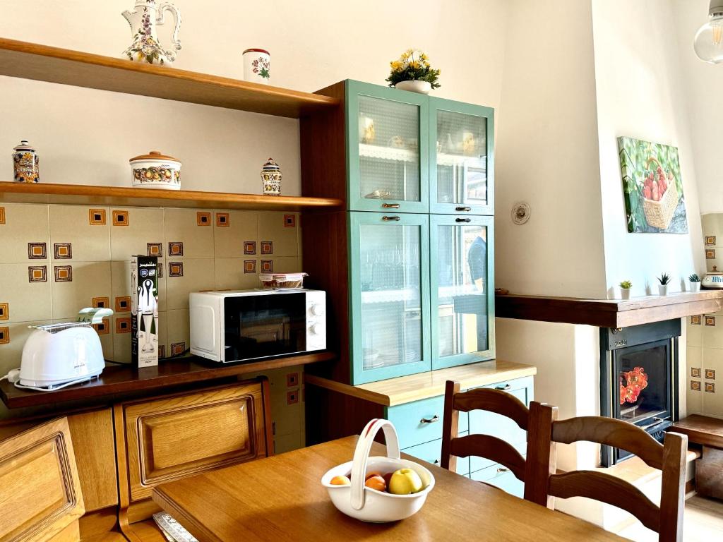 eine Küche mit Tisch und Mikrowelle in der Unterkunft Casa Burano in Capalbio