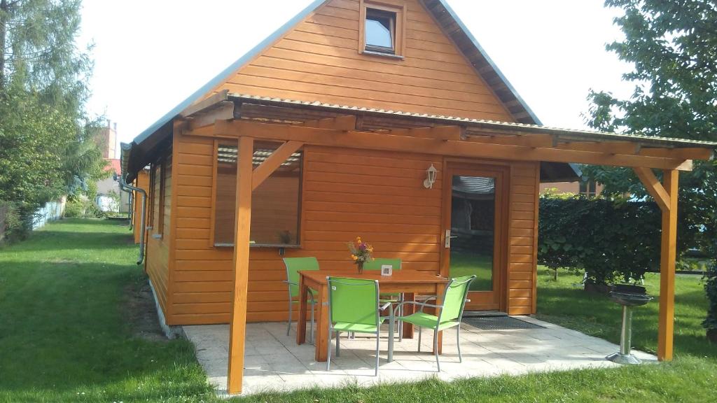 a cabin with a table and chairs in a yard at Ferienwohnungen Goller in Großkoschen