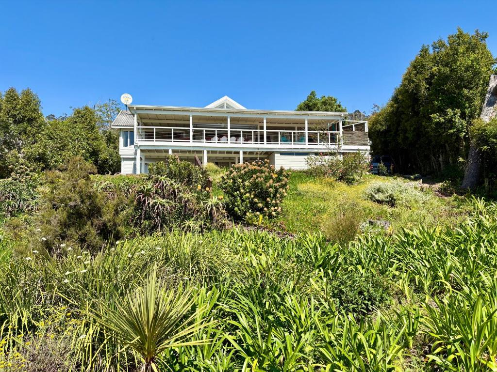 a white house on top of a hill with plants at Lagoonside Lookout in Knysna