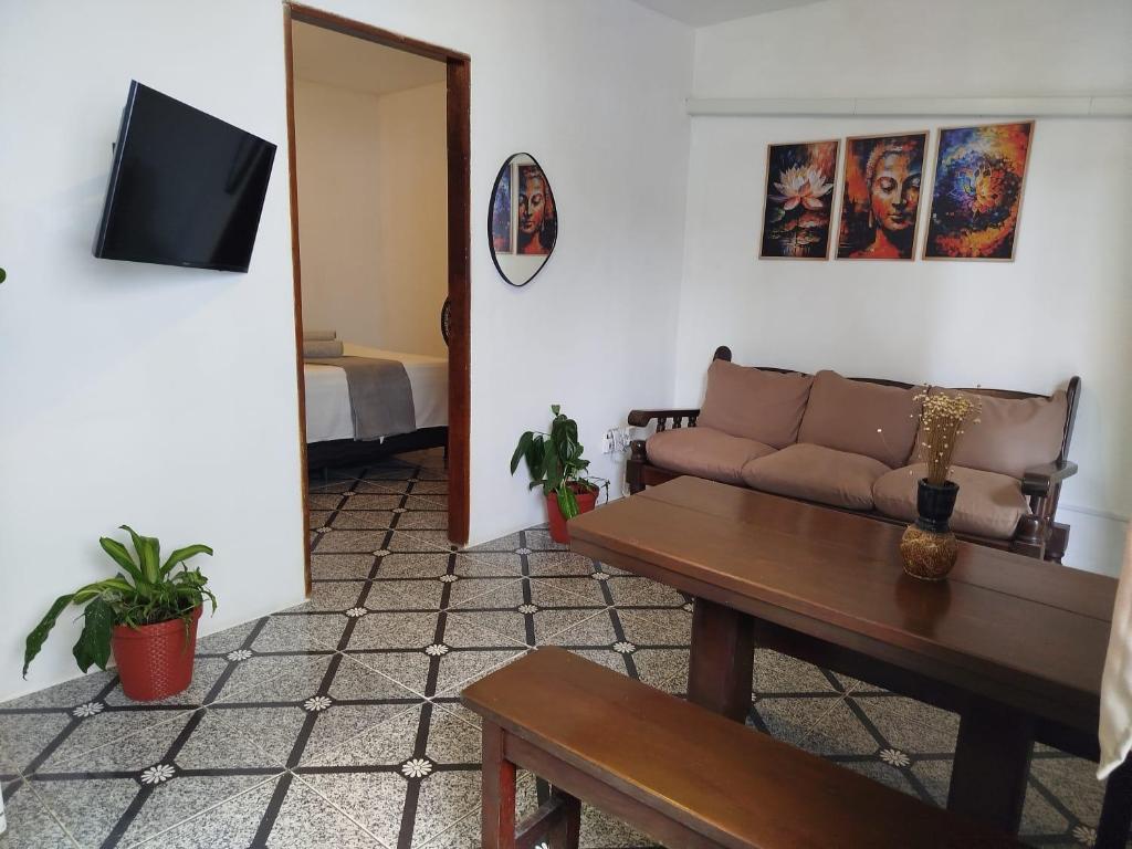 un soggiorno con un divano e un tavolo di Sunset Flats - Flat de 2 quartos bem perto das praias e na rua Pituba 1 a Itacaré