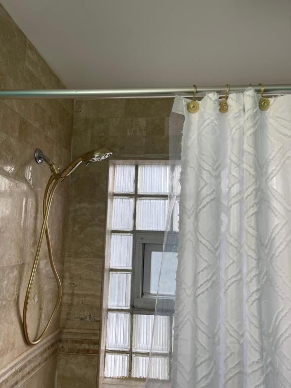 a shower curtain in a bathroom with a window at Cozy room near Airport & Highway in Saint Louis