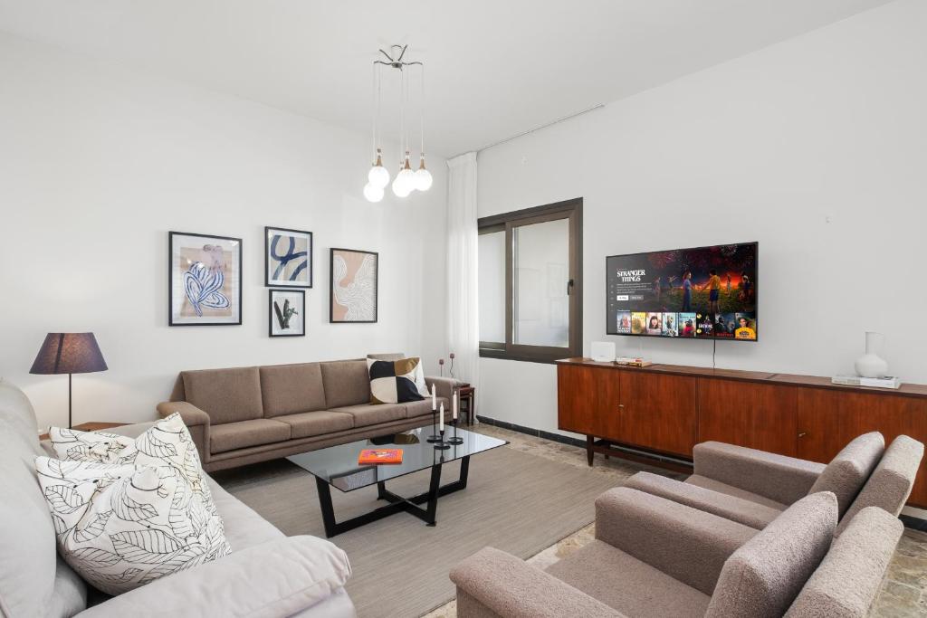 a living room with two couches and a flat screen tv at Casa Centrale by Nomads in Paphos City