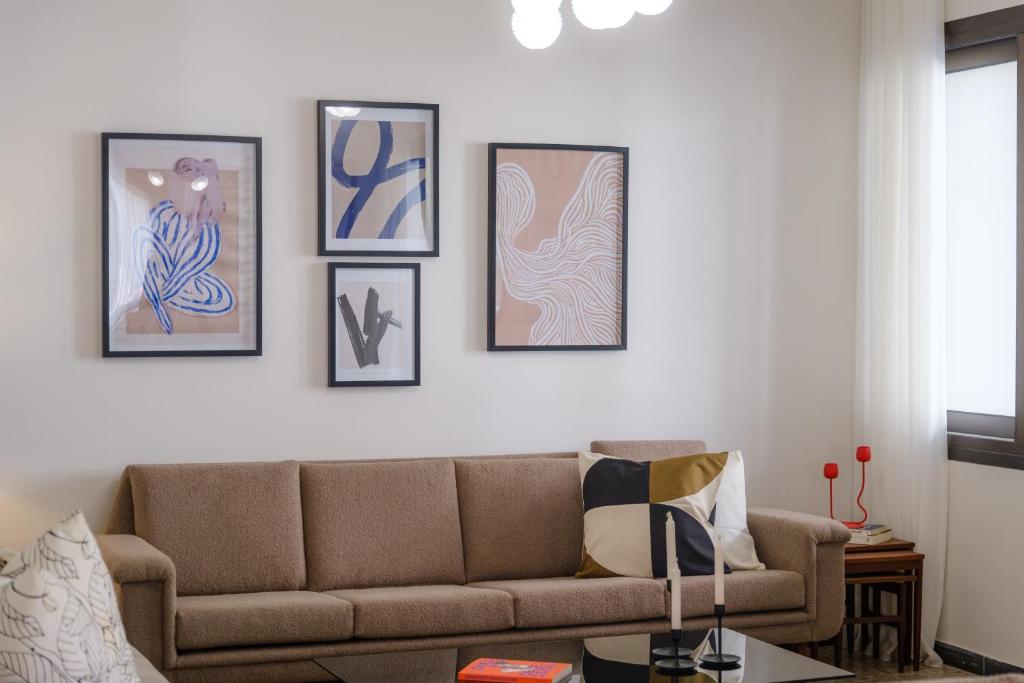 a living room with a couch and nine pictures on the wall at Casa Centrale by Nomads - 2BD Home with Workspace in Paphos