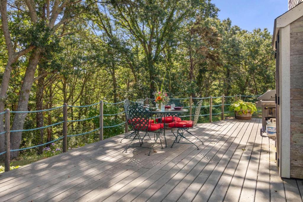 eine Terrasse mit zwei Stühlen und einem Tisch auf einem Deck in der Unterkunft Tranquil Cozy Cottage Recently Renovated in Wellfleet