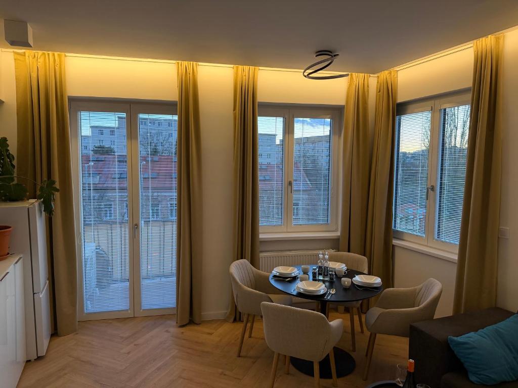 a living room with a table and chairs and windows at Lumio in Košice