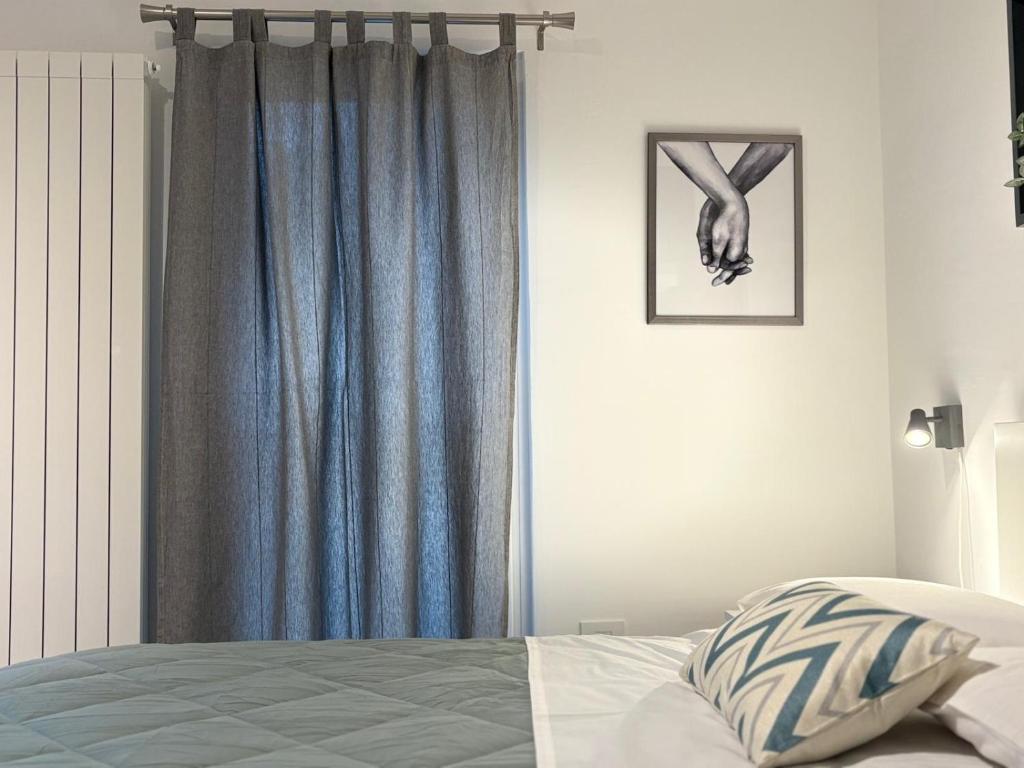a bedroom with a bed with a blue curtain at Casina al Lago in Lavena Ponte Tresa