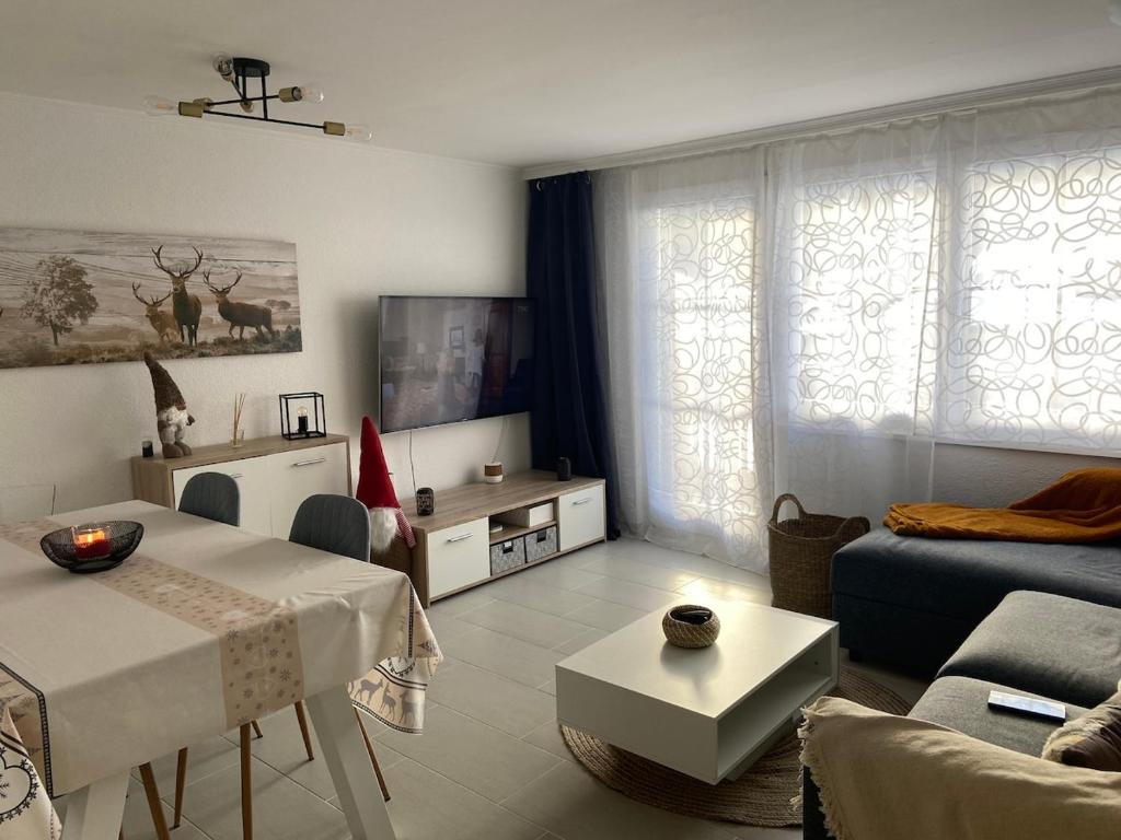 un salon avec une table et un canapé dans l'établissement Centrally located and comfortable apartment - Daubenhorn 32, à Arni Alp